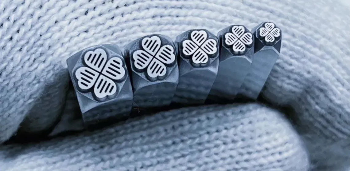 Set of metal stamps with floral designs on a textured fabric background