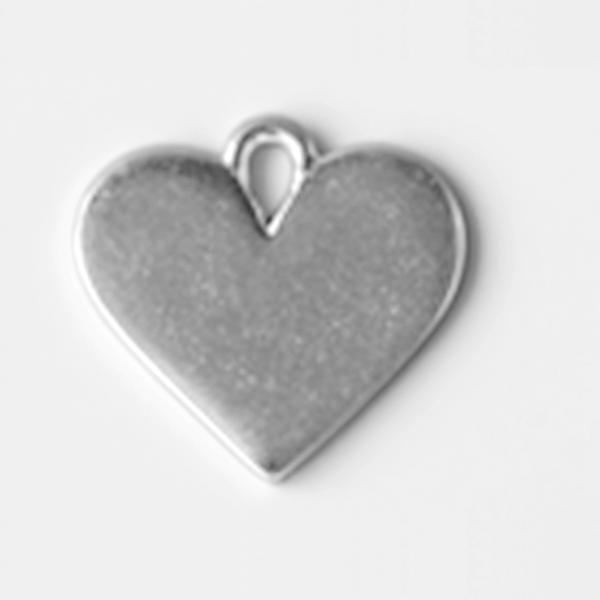 Heart-shaped silver pendant on a light gray background MetalStampingBlank